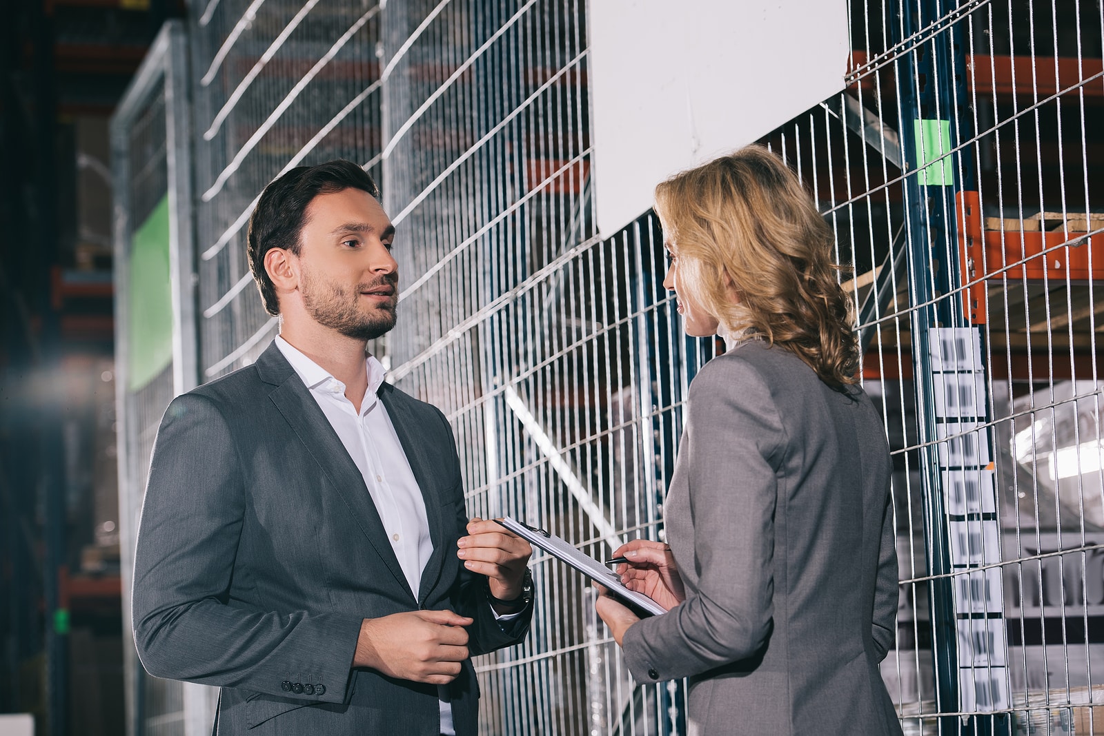 Confident Business Partners Talking While Standing In Warehouse